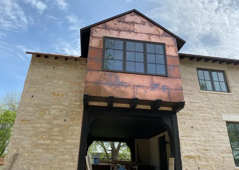 Copper metal panel facade on a stone building for Roof Repair in Fountainhead-Orchard Hills